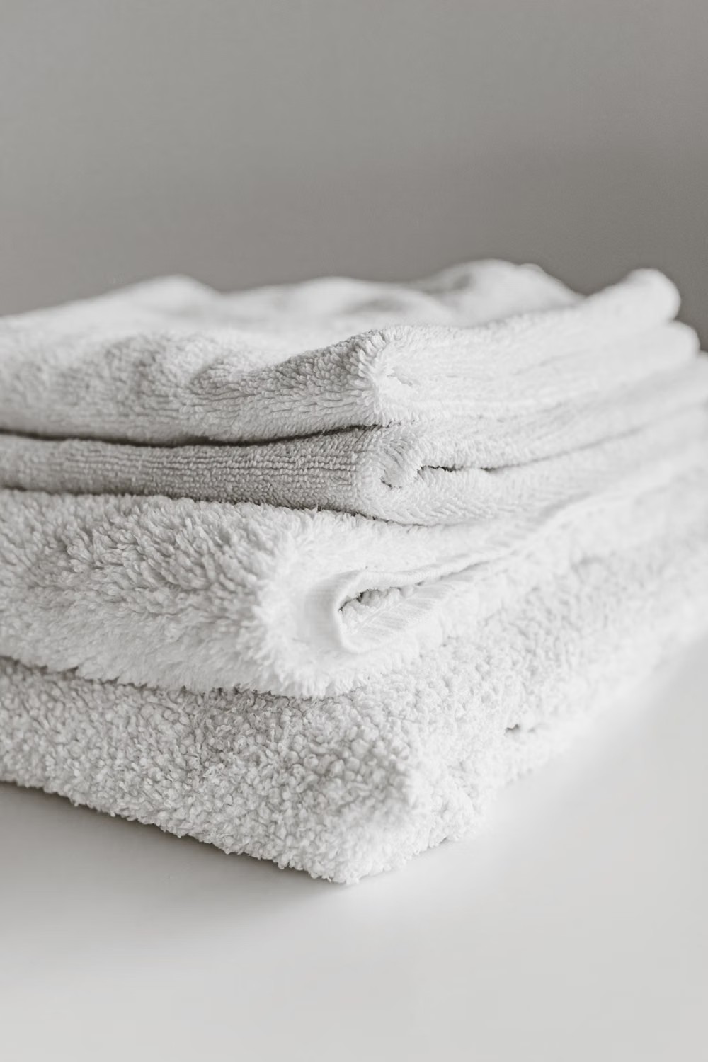 Stock photo of a neatly folded stack of white towels.