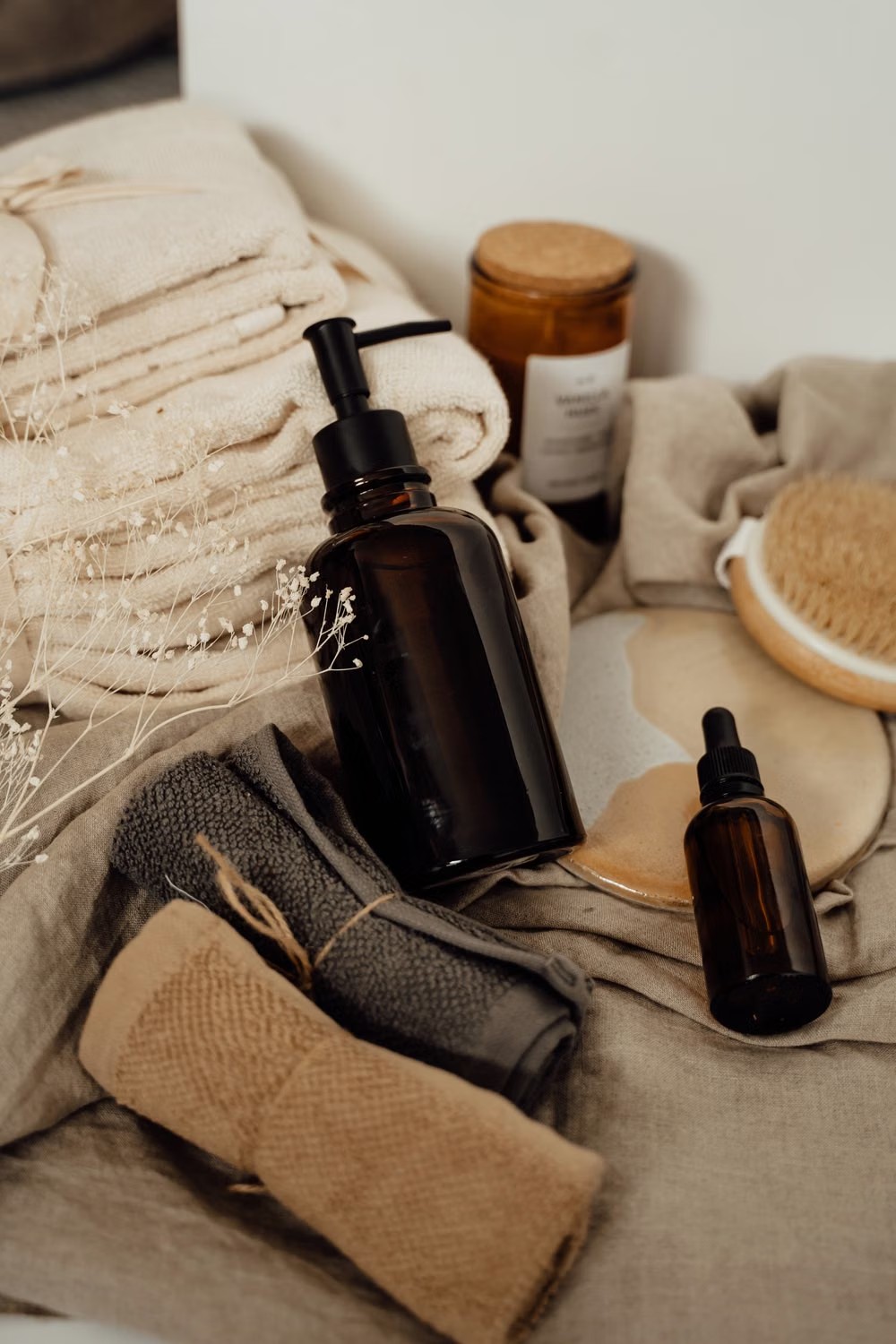 Stock photo of folded towels beside unbranded spa supplies.